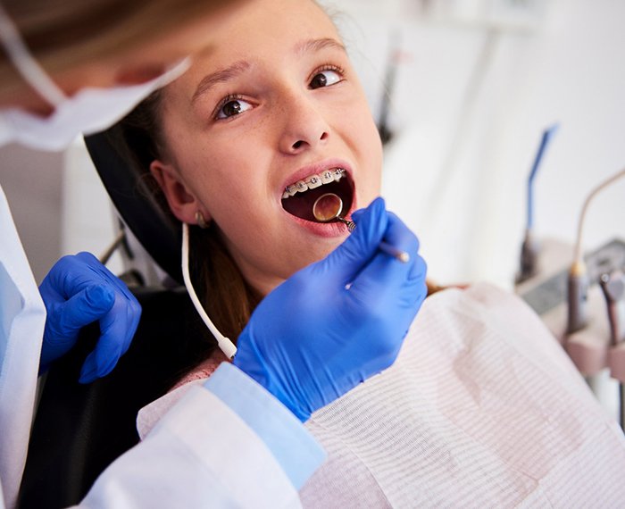 Dentist examining child's braces