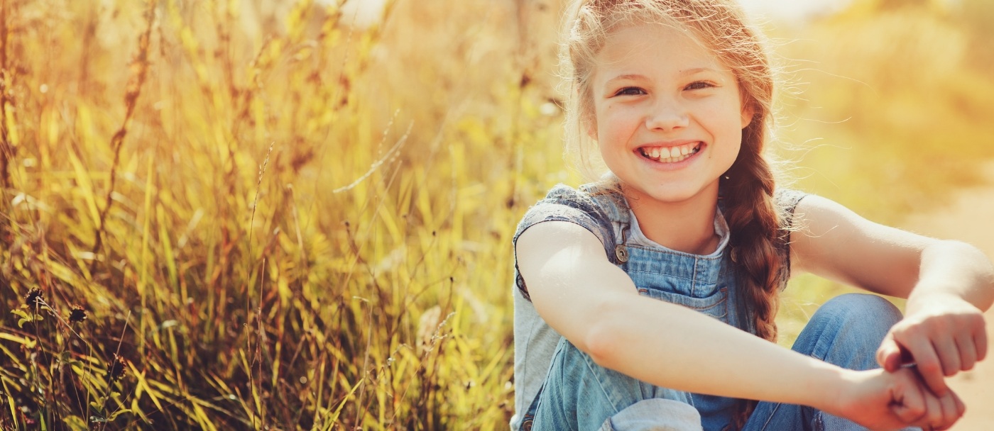 Young girl smiling outdoors after orthodontic treatment in Pleasanton