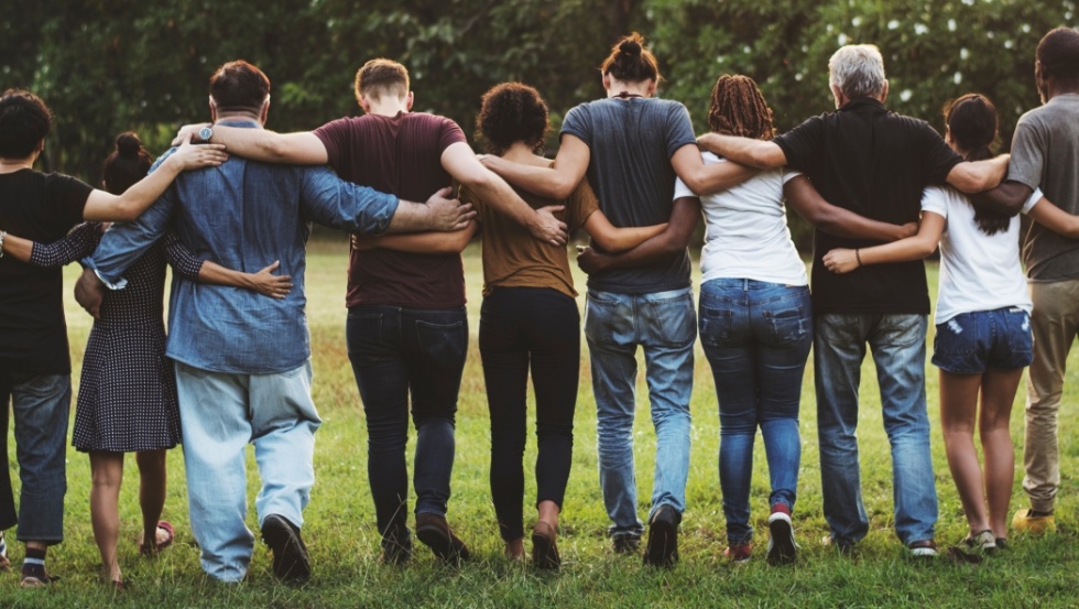 Group of people standing in line with their arms around each others shoulders