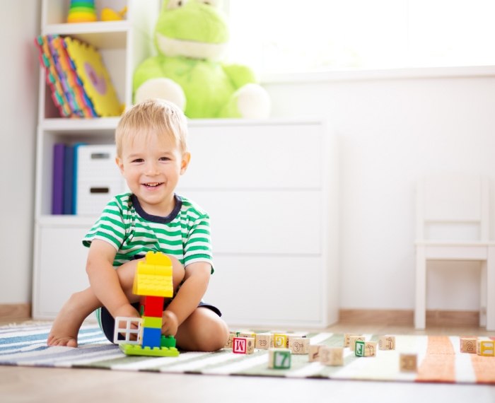 Young boy playing with block toys on the floor