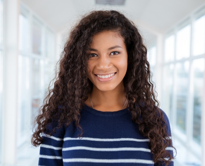 Smiling teenage girl standing in hallway