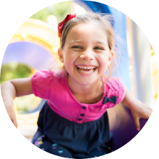 Young girl grinning on outdoor playground