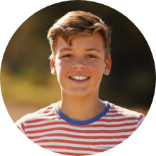 Young boy in red striped shirt smiling