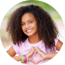 Smiling girl making a heart shape with her hands
