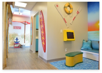 Hallway of pediatric dental office with surfboard on wall