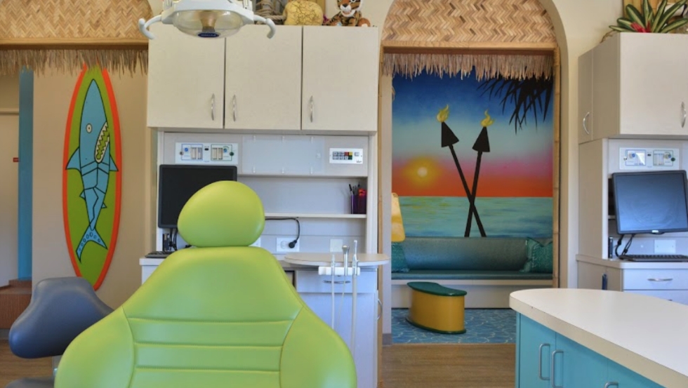 Painted wall of beach at sunset with dental chair in foreground