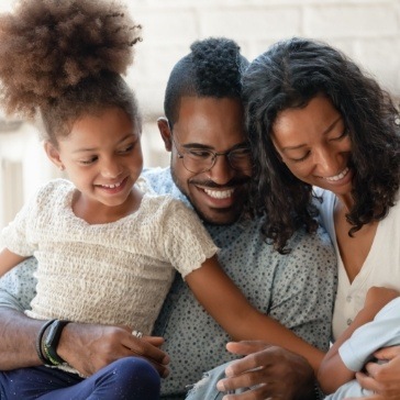 Family of four smiling on couch