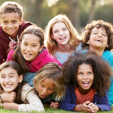 Group of smiling kids laughing together outdoors