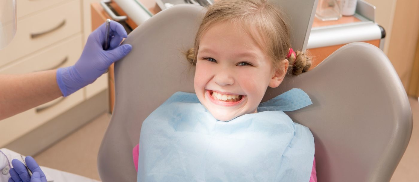 Young girl grinning in dental chair after pediatric dental services in Pleasanton