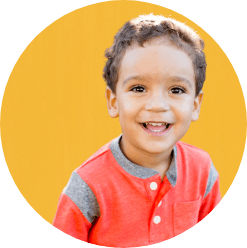 Young boy in orange shirt smiling