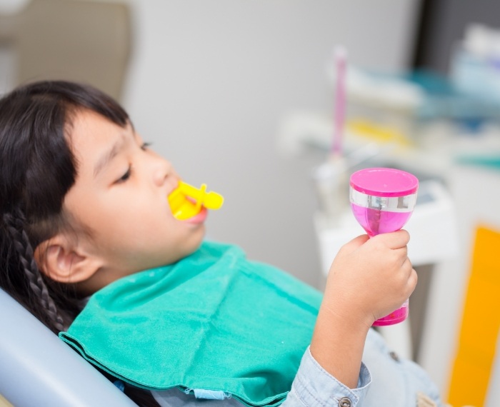 Young girl in dental chair with fluoride trays on her teeth