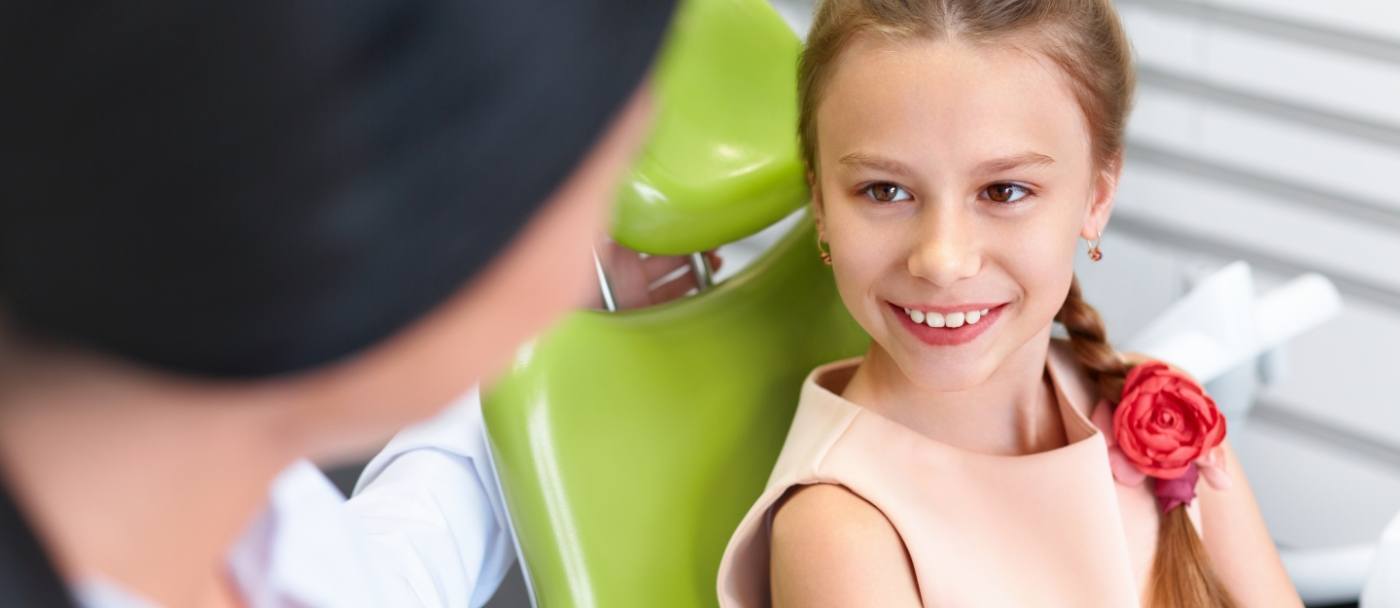 Young girl in dental chair smiling at her pediatric emergency dentist in Pleasanton