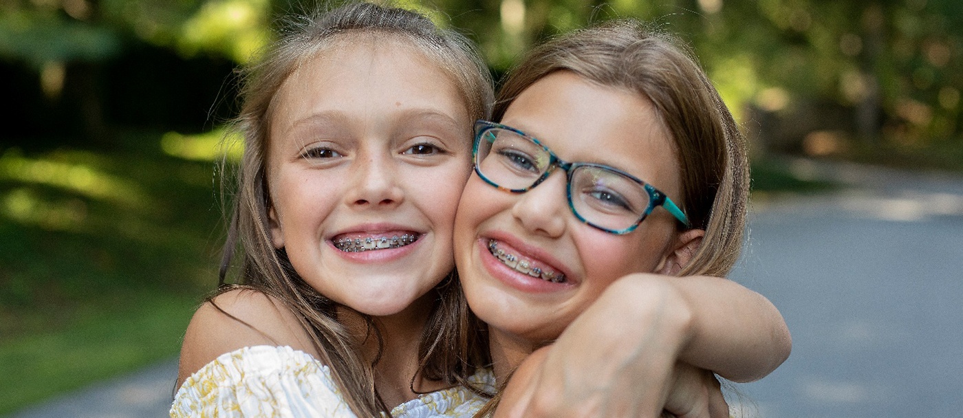 Two girls with braces embracing each other