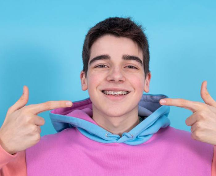 Teen boy pointing at his orthodontic braces