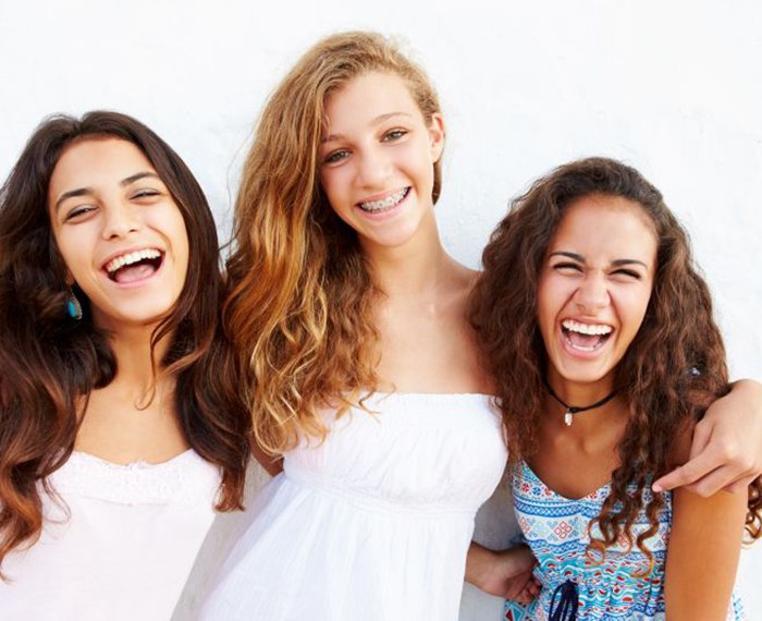 Group of teen girls, with the middle girl wearing braces