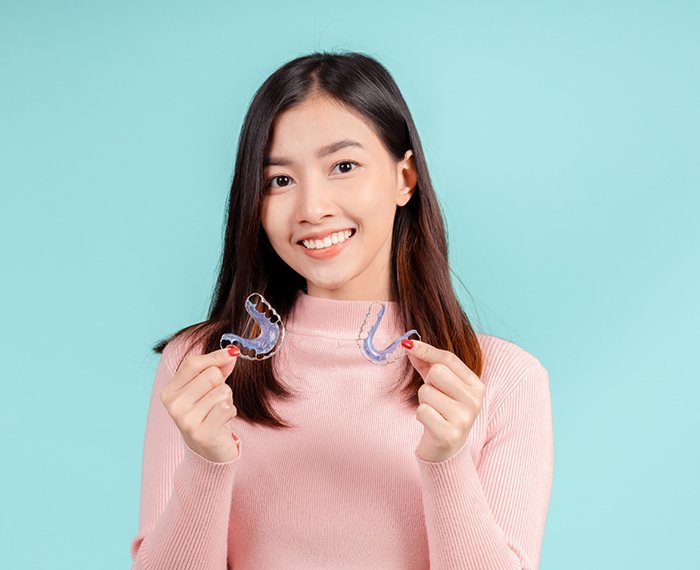 Teen girl holding two orthodontic retainers
