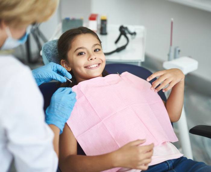 Happy girl in dental treatment chair