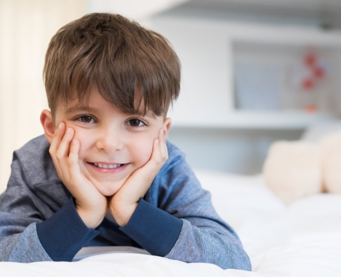 Smiling boy laying on his stomach