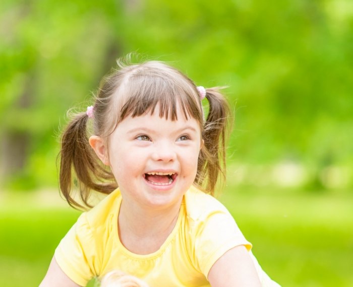 Young girl with special needs smiling outdoors