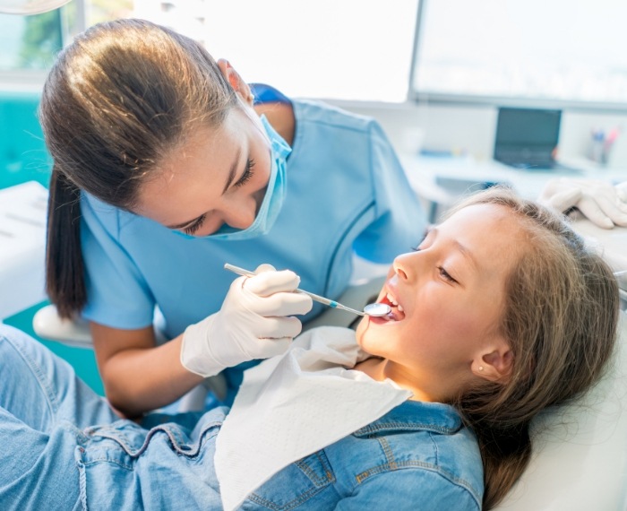 Pleasanton pediatric dentist giving a young girl a dental exam