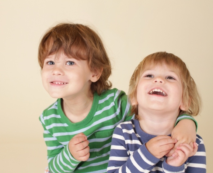 Two smiling children in striped shirts