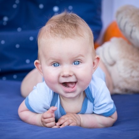 Smiling baby laying on their stomach