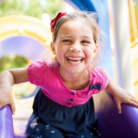 Young girl laughing on outdoor playground