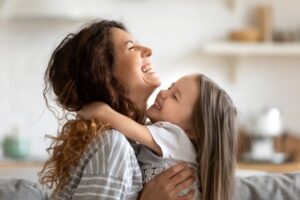 Mother and child laughing as they embrace one another 